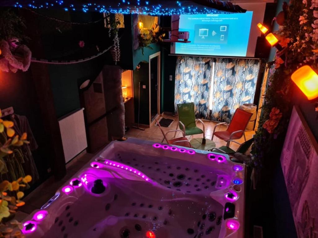 Saint-MauriceにあるVilla Maelio Jacuzzi Sauna et Salle de jeux - Privatifの紫色の照明付きのバスタブが備わる客室です。