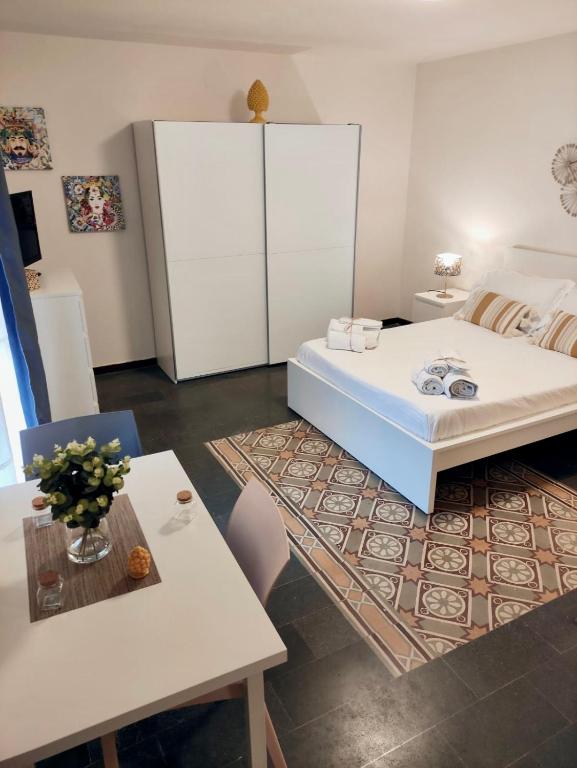 Un dormitorio con una gran cama blanca y una mesa. en Ostro - Guest House, en Agrigento