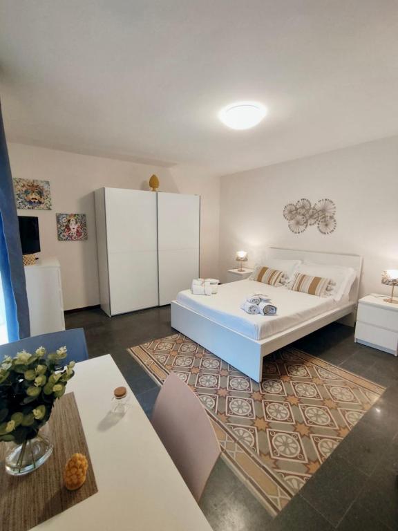 Un dormitorio con una gran cama blanca y una mesa. en Ostro - Guest House, en Agrigento