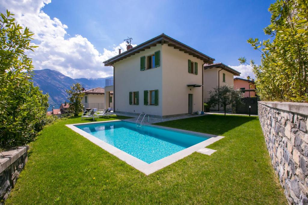 a backyard with a swimming pool in front of a house at Villa Inti in Tremezzo