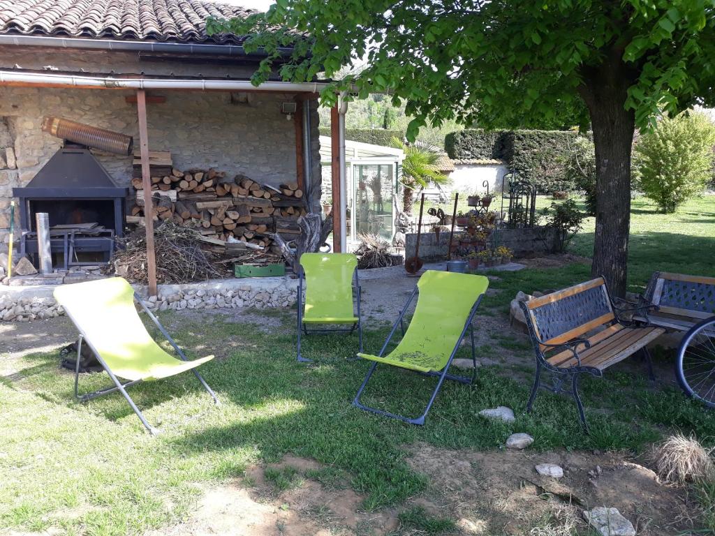 a group of chairs sitting in the grass in a yard at Un jardin sur la colline in Claveyson