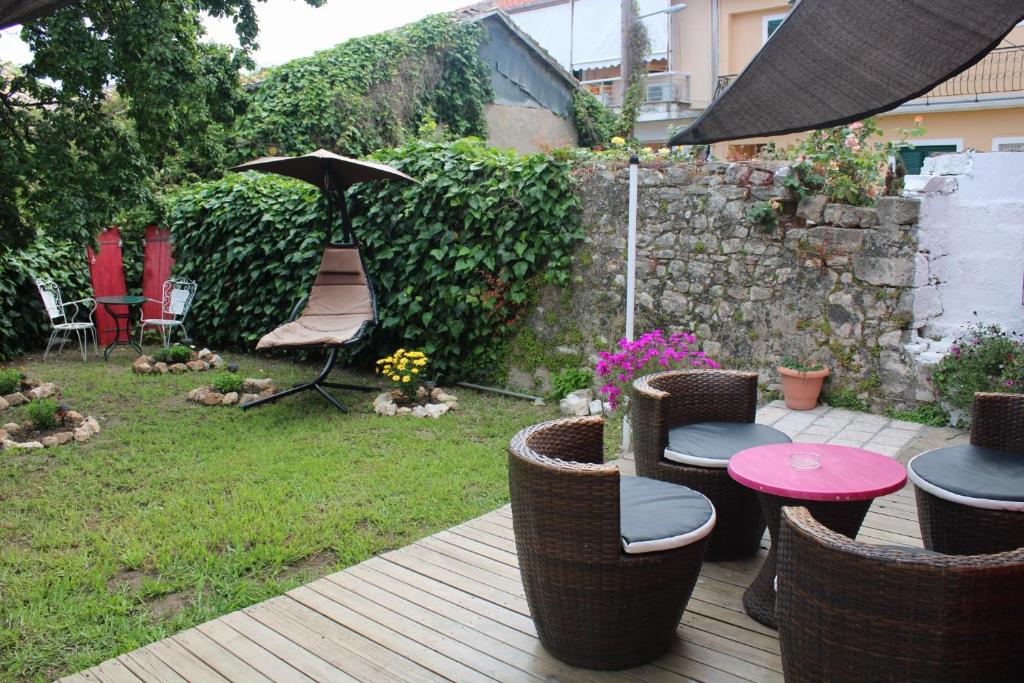 a patio with a table and chairs and an umbrella at PENELOPE'S STREET OLD HOUSE in Lefkada