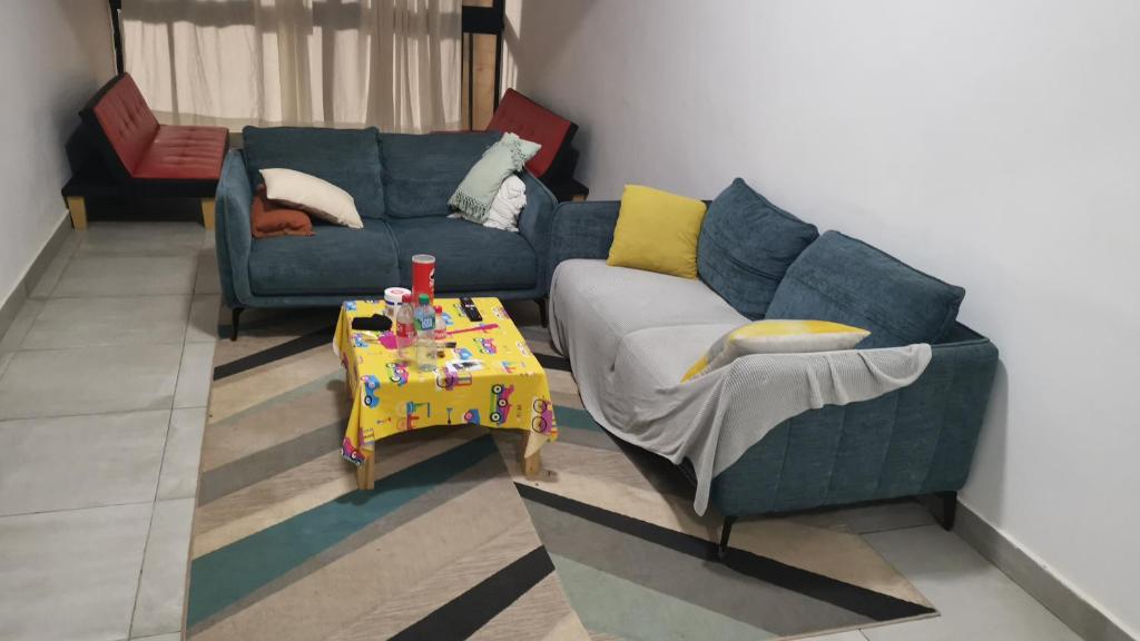 sala de estar con sofá azul y mesa en Résidence Maty - 2 chambres salon en Grand Médina