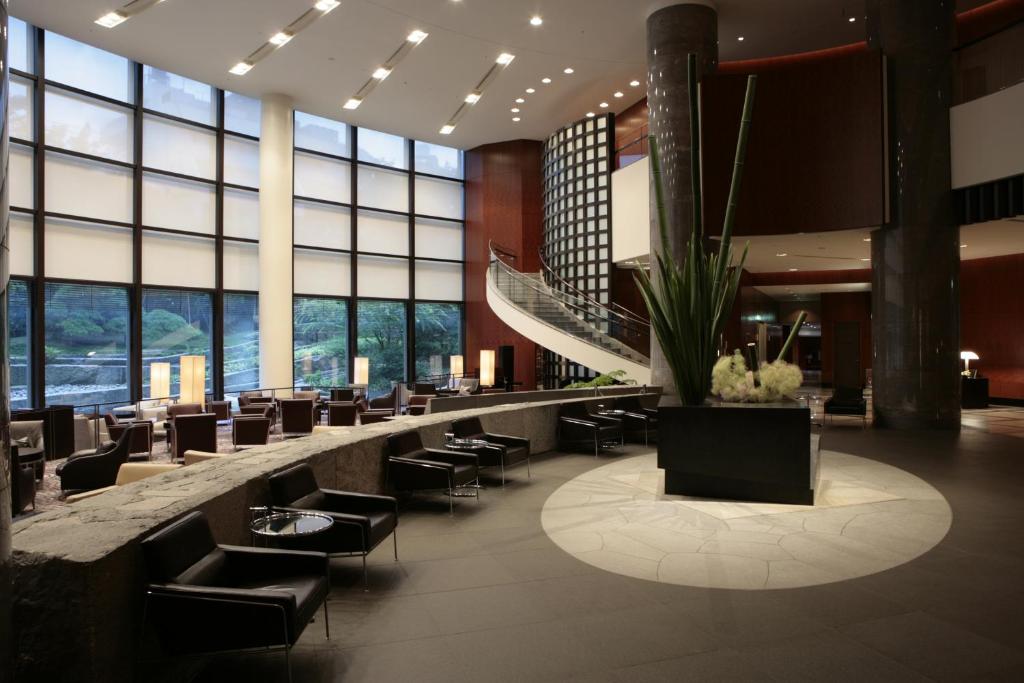 a lobby with chairs and tables and windows at Cerulean Tower Tokyu Hotel, A Pan Pacific Partner Hotel in Tokyo