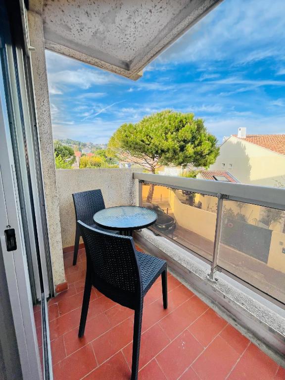 un patio avec une table et des chaises sur un balcon dans l'établissement Studio Plage, à Marseille