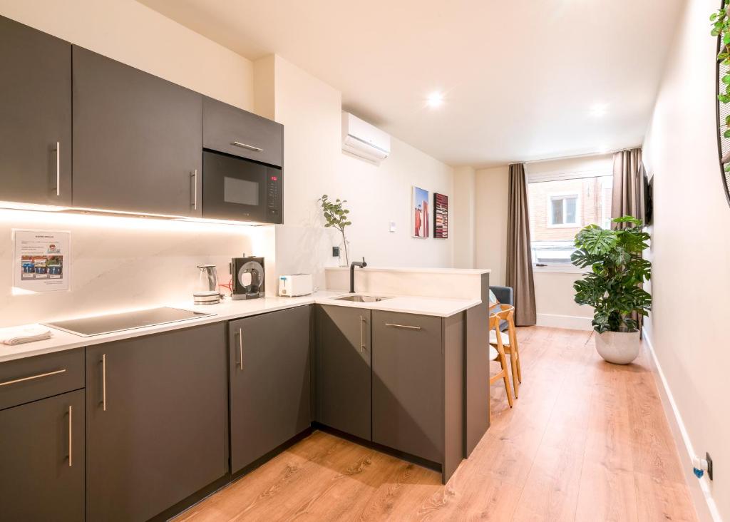 a kitchen with gray cabinets and a sink at BILBAO RIVERSIDE by STAYNN APARTMENTS in Bilbao