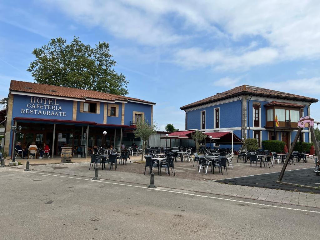 a group of tables and chairs in front of a building at Hotel Villa Maria in Revilla de Camargo