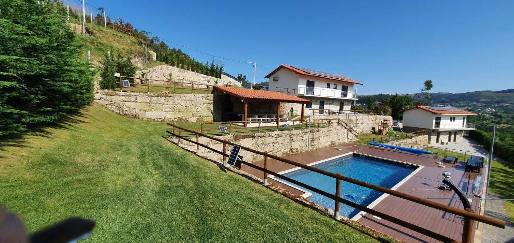 een huis met een zwembad naast een hek bij Quinta de Terreiros 16 Pax - Quinta Inteira in Cabeceiras de Basto