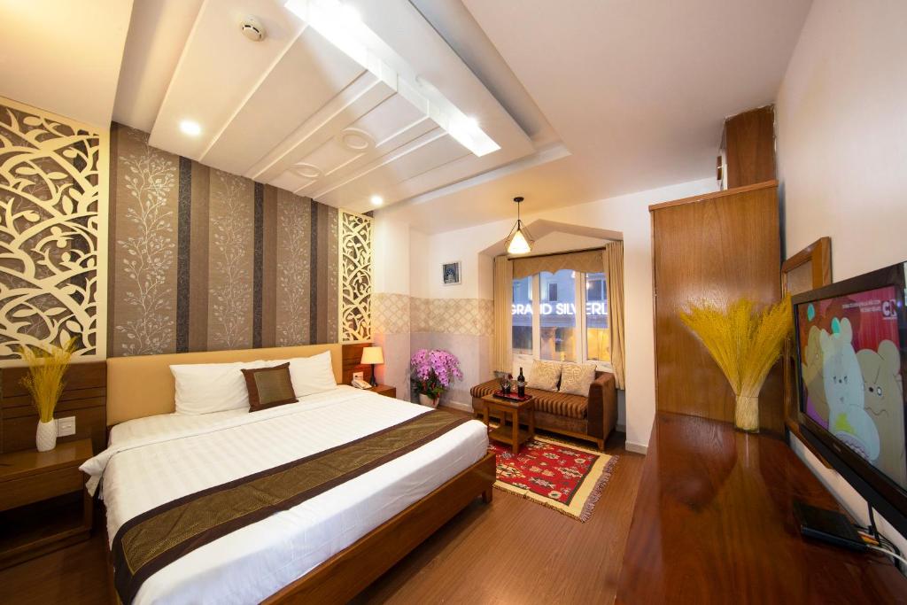 1 dormitorio con 1 cama y sala de estar en Vilion Boutique Hotel Ben Thanh en Ho Chi Minh