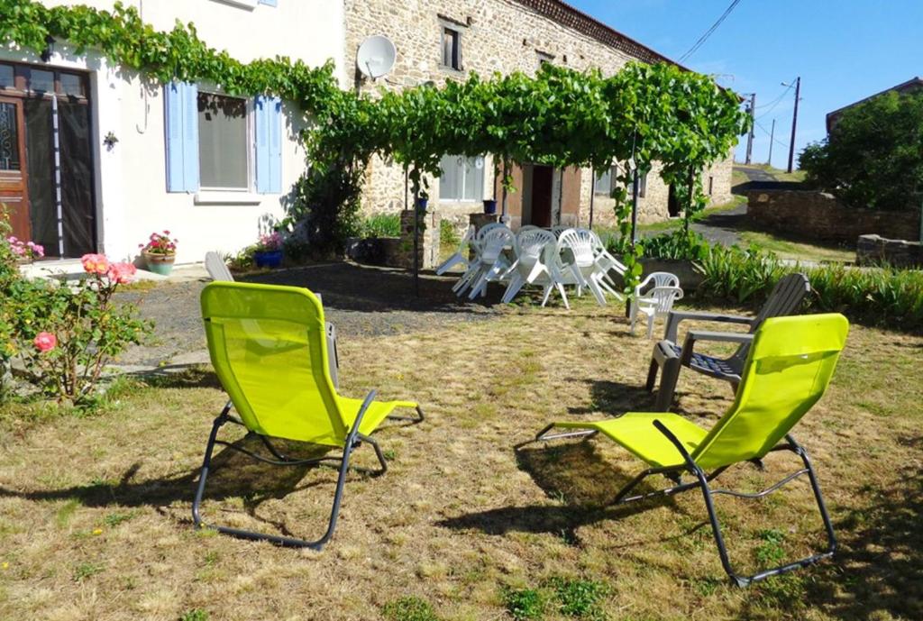 two green chairs and a table in a yard at Maison charmante à Mercœur avec jardin et parking in Mercoeur
