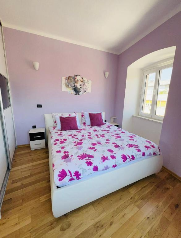 a bedroom with a large bed with purple walls at Apartment Tashi, Korzo - Rijeka, 2 bedrooms in Rijeka