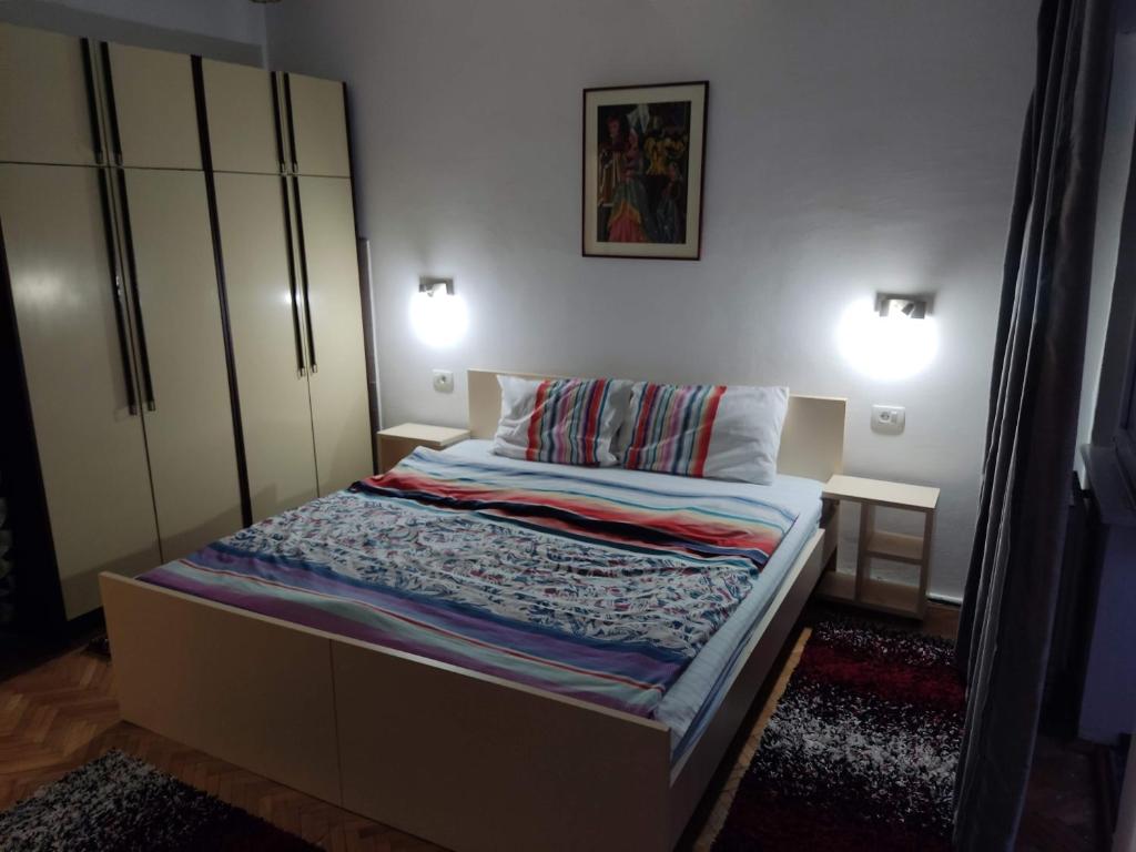 a small bedroom with a bed and two lamps at Zozi urban studio in Skopje