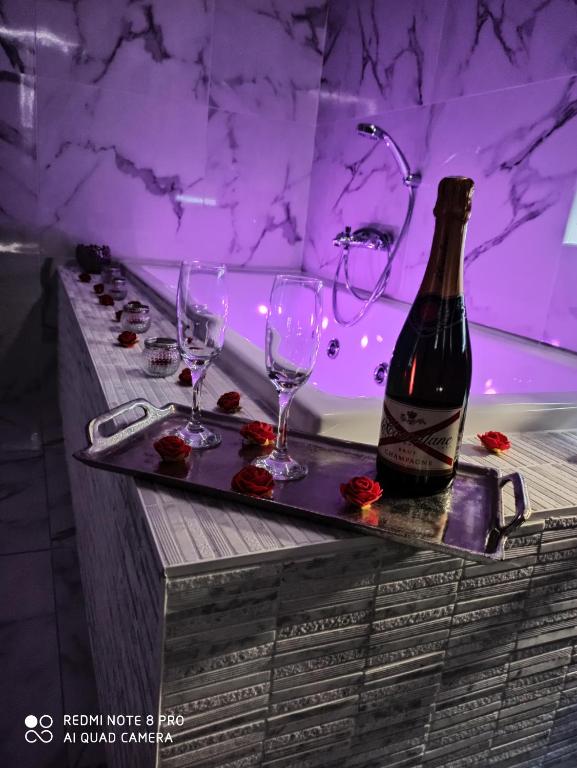 - une baignoire avec une bouteille de vin et deux verres dans l'établissement Triplex 110 m2 centre historique avec jacuzzi DINAN, à Dinan