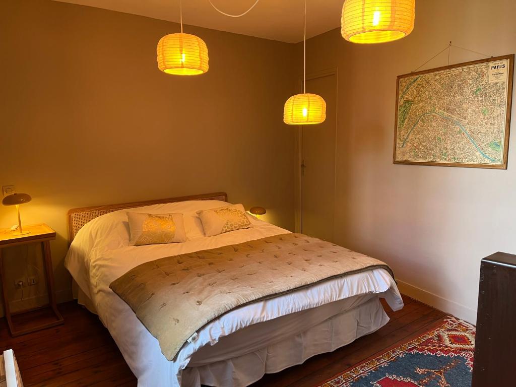 - une chambre avec un lit avec deux lampes et une carte dans l'établissement Ma Bohème - Jardin en Centre historique, à Honfleur