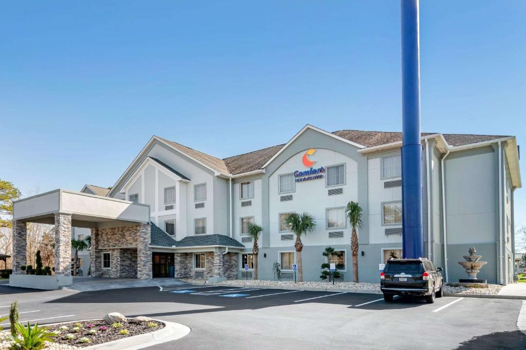 a hotel with a car parked in a parking lot at Comfort Inn & Suites Macon North I-75 in Macon