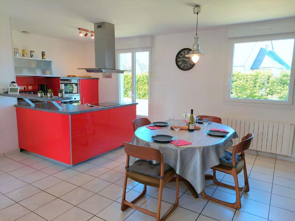 - une cuisine avec une table et un îlot rouge dans une chambre dans l&#39;établissement Single storey holiday home near the beach, Santec, à Santec