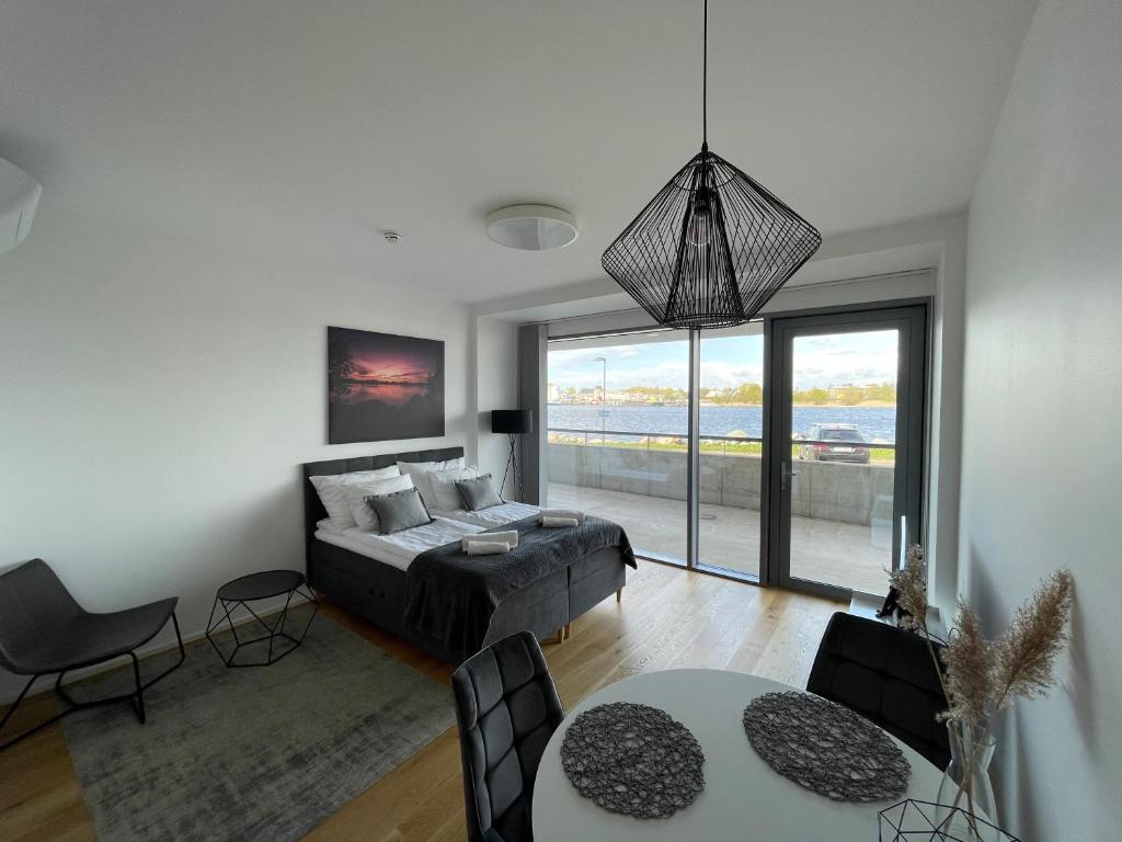 um quarto com uma cama e uma sala de estar com uma mesa em Rannakivi Riverside apartments em Pärnu