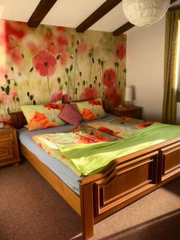 a bedroom with a large bed with flowers on the wall at Antjes Schmankerlhotel und Restaurant in Tröstau