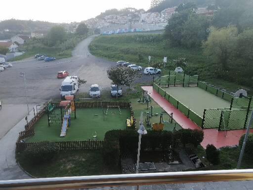 a parking lot with cars parked on a golf course at Piso en Raxó in Raxo