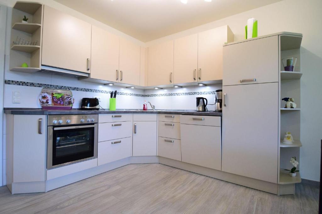 uma cozinha com armários brancos e um frigorífico em Haus Deichkieker Apartment 1 6 Deichschaf em Büsum