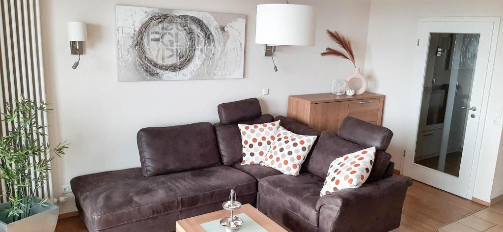 a living room with a brown couch and a table at Haus Ankerplatz Apartment 2 2 in Büsum