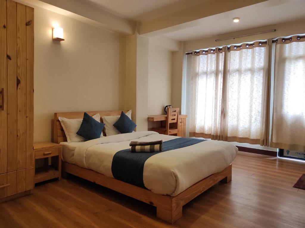 a bedroom with a large bed with blue pillows at Awale House in Pātan