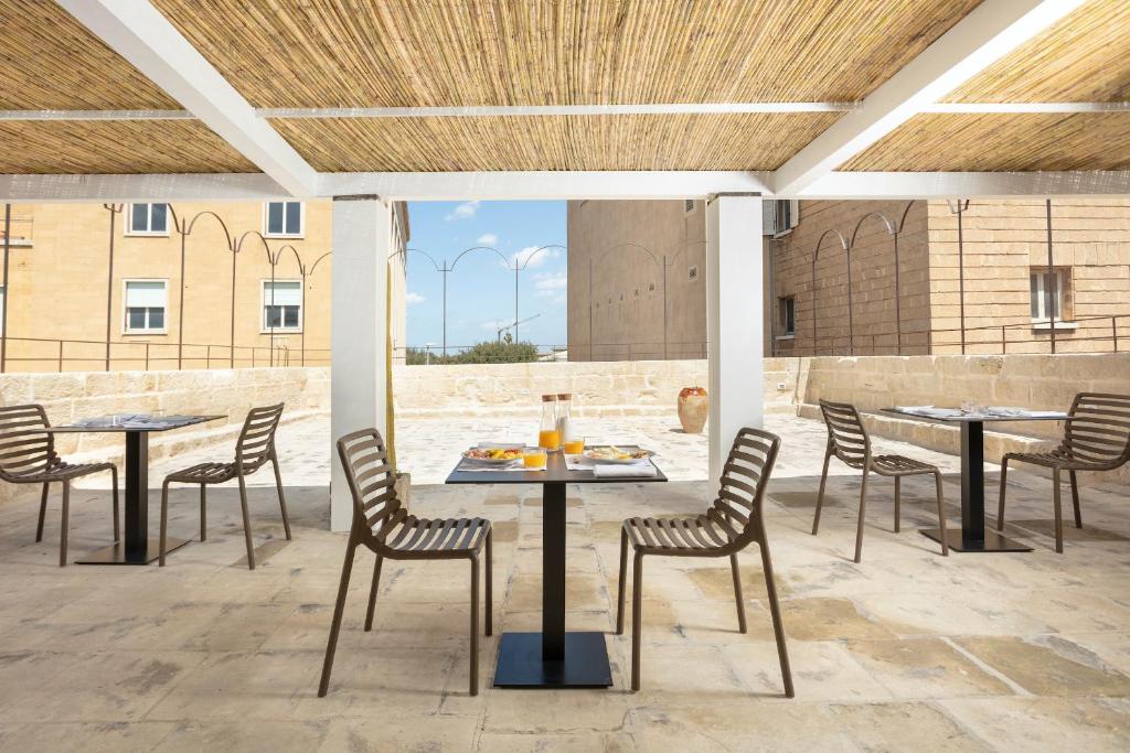 un patio con tavoli e sedie in un edificio di Palazzo dei Tolomei a Lecce