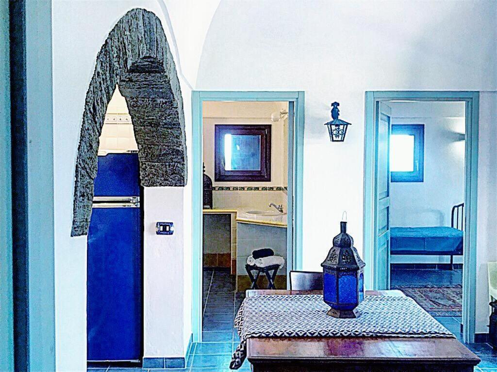 a living room with a blue door and a table at dammuso dehors in Pantelleria