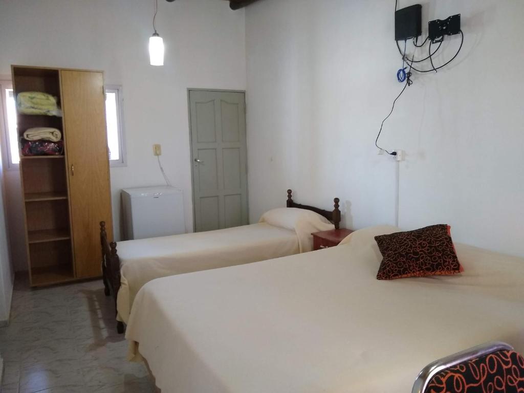 um quarto de hotel com duas camas e uma janela em Departamentos PAEZ em Malargüe