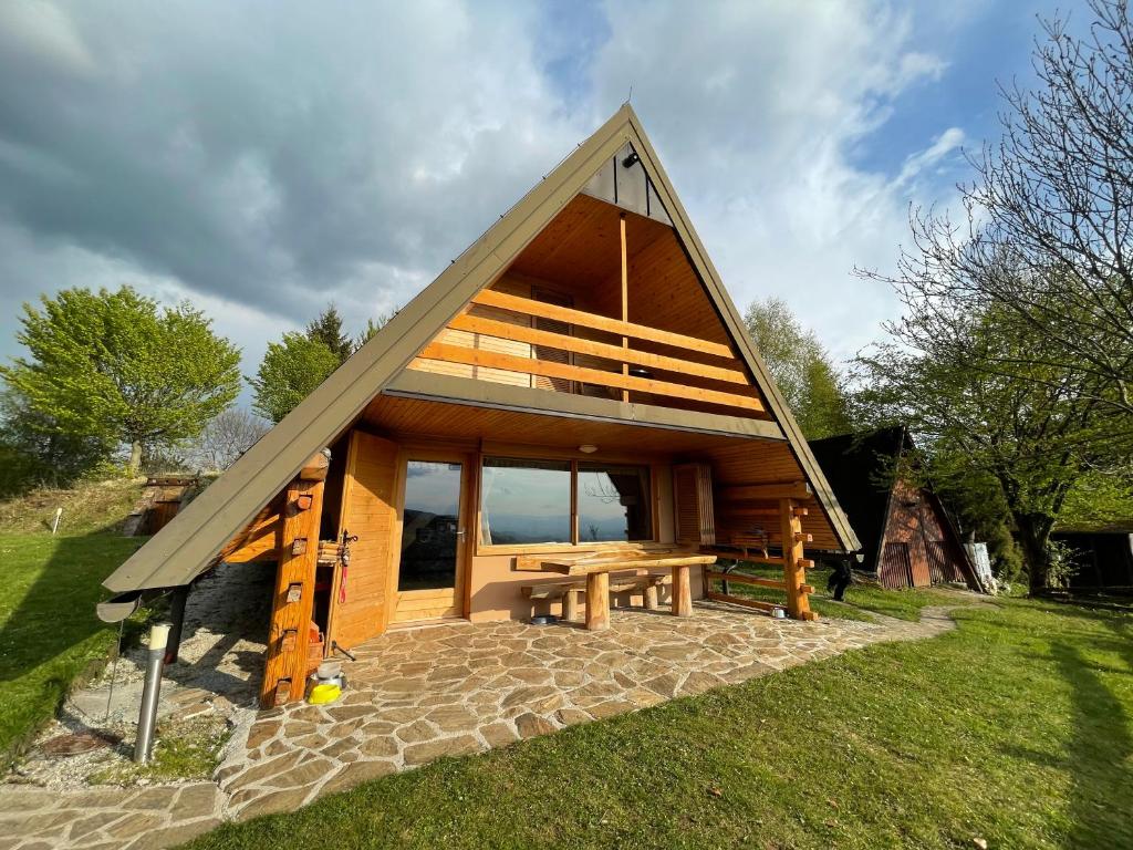 Cabaña pequeña con techo inclinado y mesa de picnic en Mountain view cottage, en Kamnik