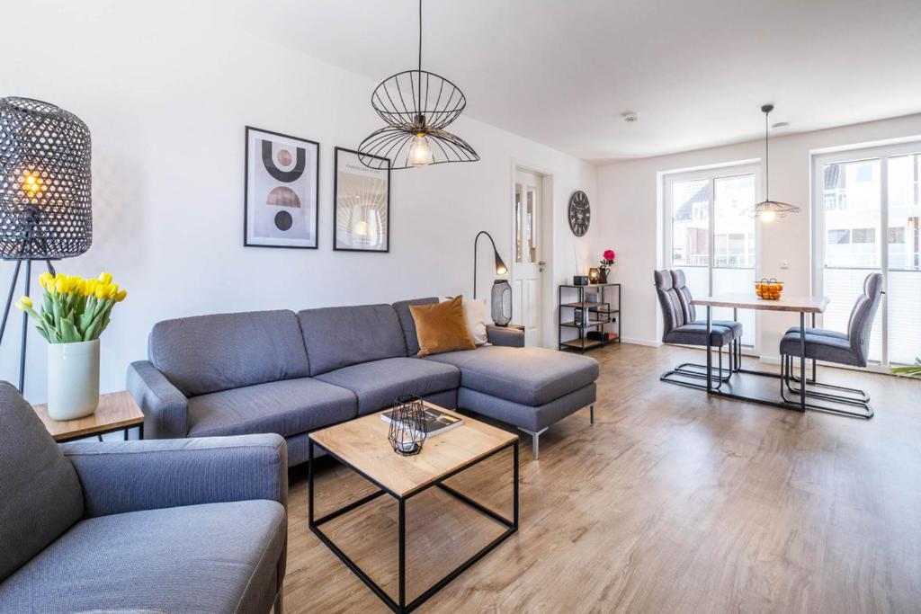 sala de estar con sofá y mesa en Haus Hummerklippe Apartment 4, en Büsum