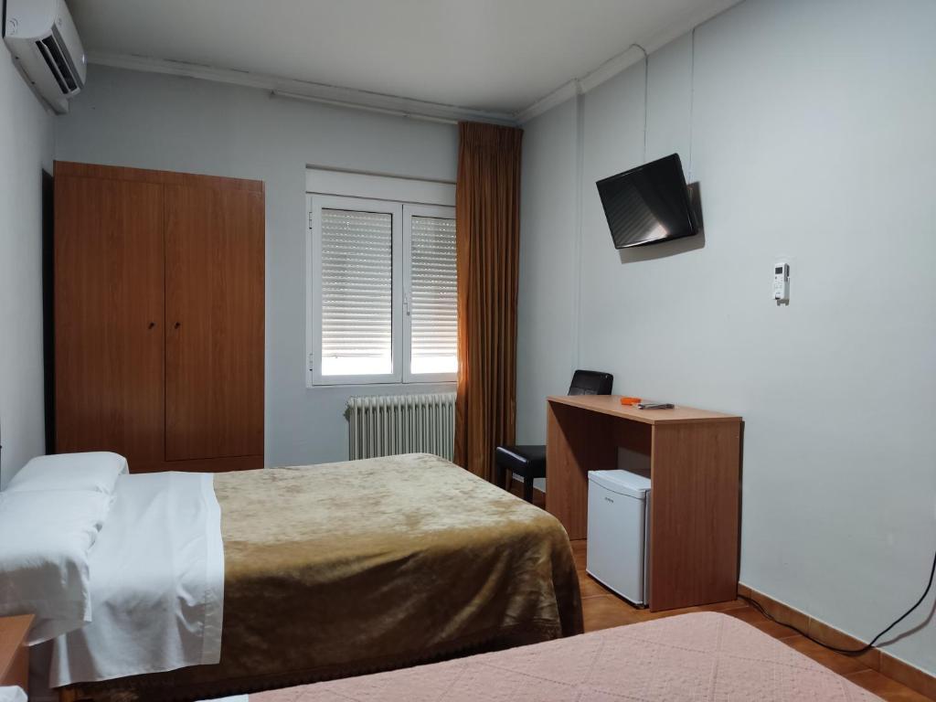 a bedroom with a bed and a desk and a television at Hotel Europa in Tomelloso