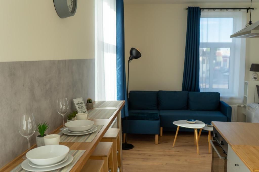 a living room with a blue couch and a table at Cozy Apartment at Central Market - Liepajas heart in Liepāja