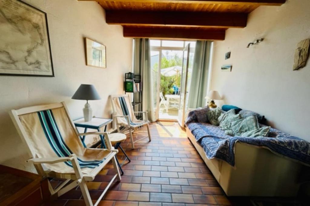 uma sala de estar com um sofá, cadeiras e uma mesa em House Rétaise With Garden Close To The Sea em La Couarde-sur-Mer