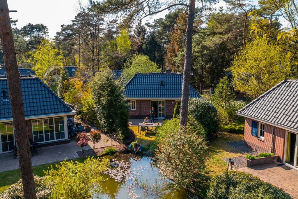 een luchtzicht op een huis met een vijver bij EuroParcs Beekbergen in Beekbergen