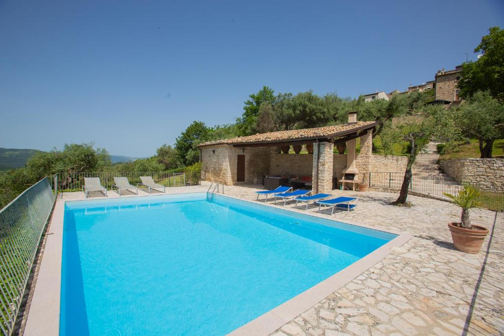 a swimming pool with chairs and a house at Casa Cristina in Ripabottoni