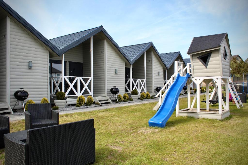a playground with a slide in front of a house at DOMKI SILVER 2 in Jarosławiec