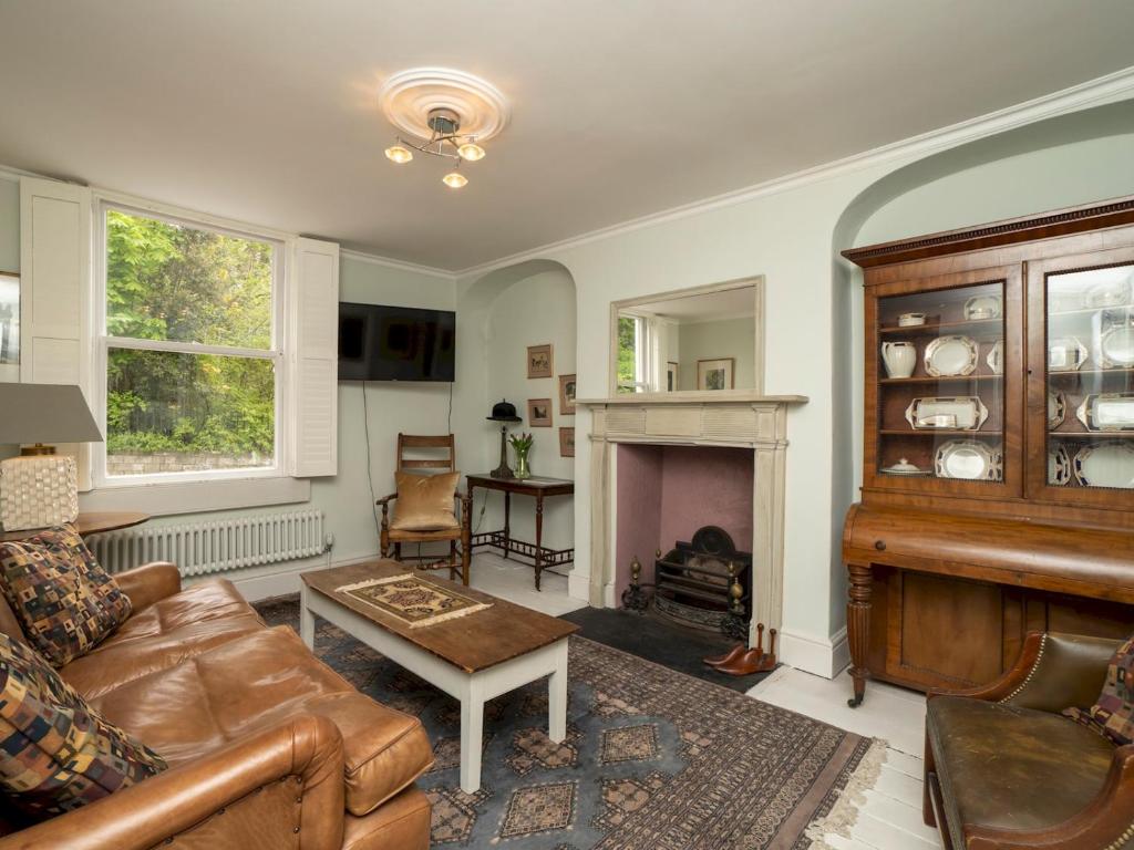 sala de estar con sofá y chimenea en Pass the Keys Charming 3 bed townhouse next to Victoria Park, en Bath