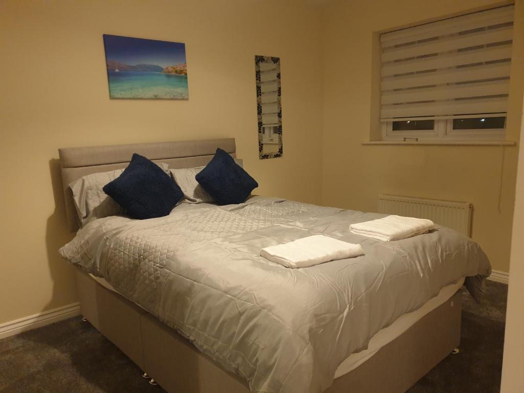 1 dormitorio con 1 cama con almohadas azules en Cheerful 4 Bedroom Townhouse with free parking en Kenton