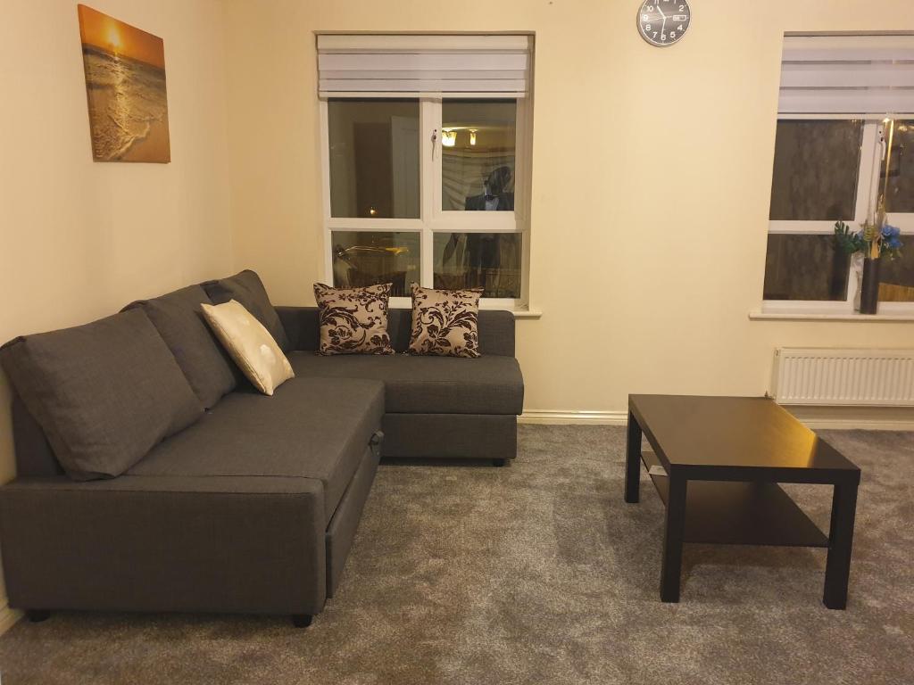 uma sala de estar com um sofá e uma mesa em Cheerful 4 Bedroom Townhouse with free parking em Kenton