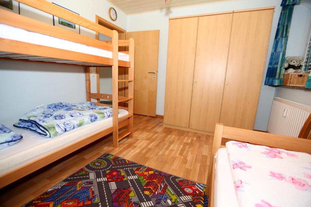 1 Schlafzimmer mit 2 Etagenbetten und einem Sofa in der Unterkunft Ferienwohnung Maria Waldblick in Burtenbach