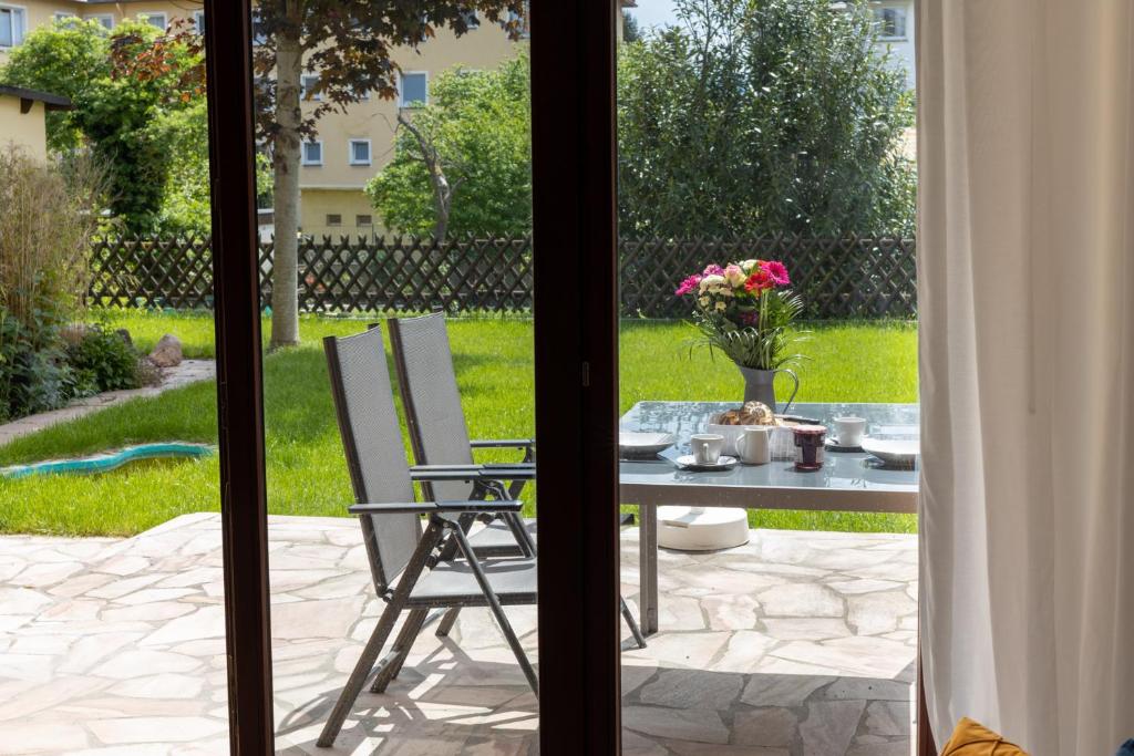 a table and chairs on a patio with a table and flowers at Lahn-Living I - Gartenapartment - modern und hell in Lahnstein