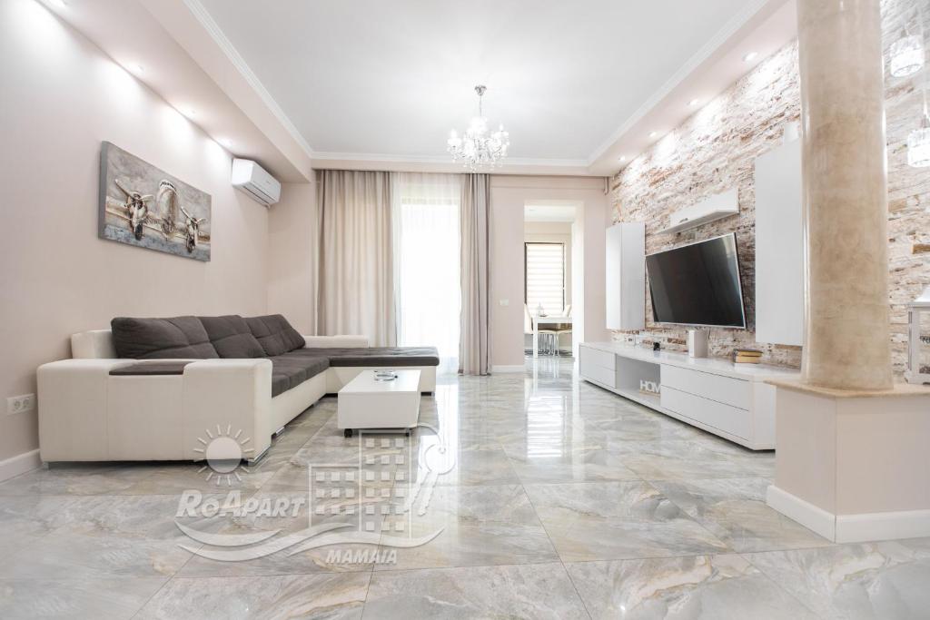 a living room with a couch and a tv at RoApart Mamaia- Sunset Dream in Mamaia