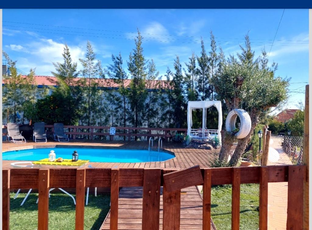 einen Hinterhof mit einem Pool und einem Holzzaun in der Unterkunft Casa do Poço Velho in Grândola
