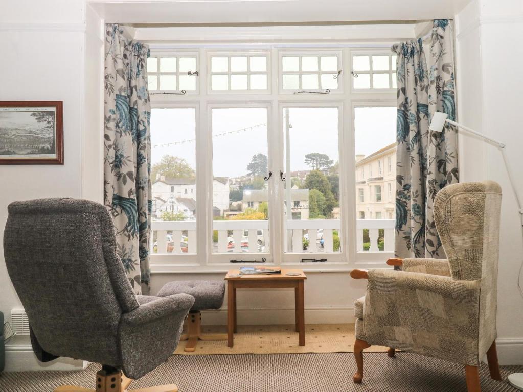 sala de estar con 2 sillas y ventana en Clarendon House en Dawlish