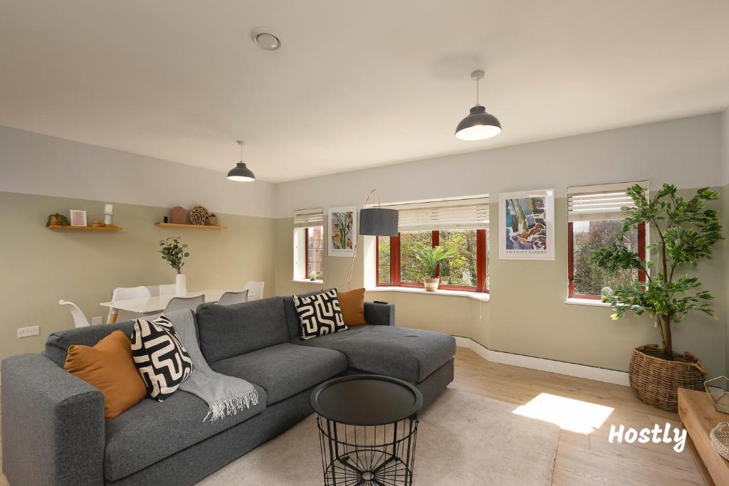 a living room with a gray couch and a table at Wesley Gate Apartments - by Hostly in Reading