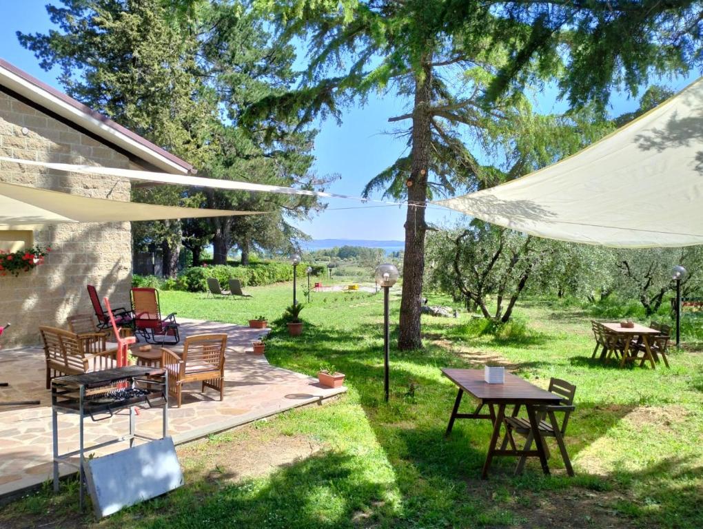patio ze stołami i krzesłami oraz białym parasolem w obiekcie Agriturismo La Villetta w mieście San Lorenzo Nuovo