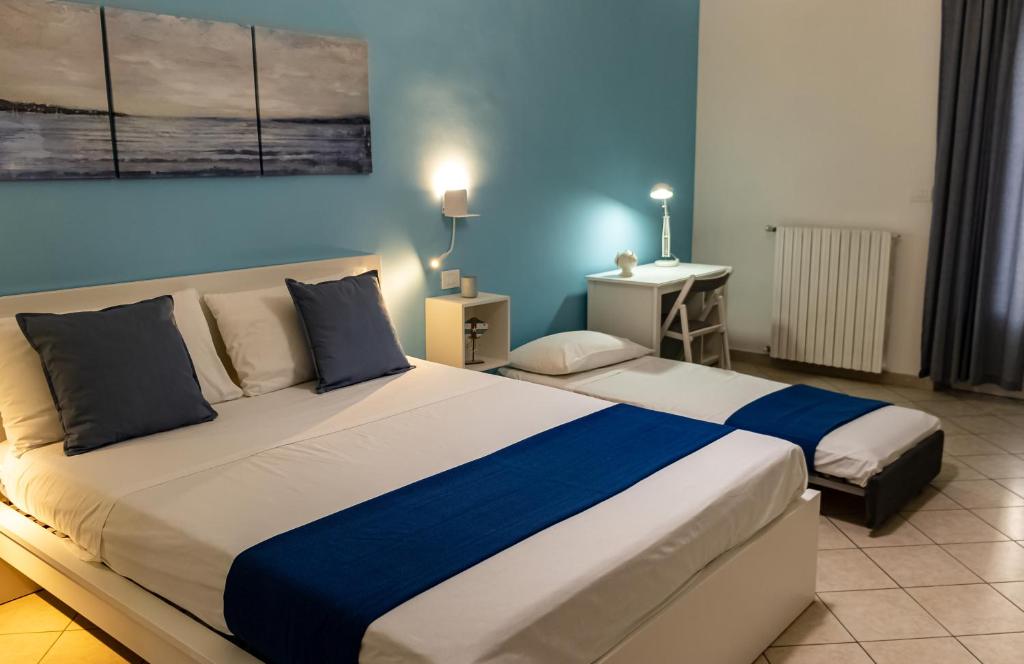 a bedroom with two beds and a blue wall at Blu Salina - Casa Vacanze in Margherita di Savoia