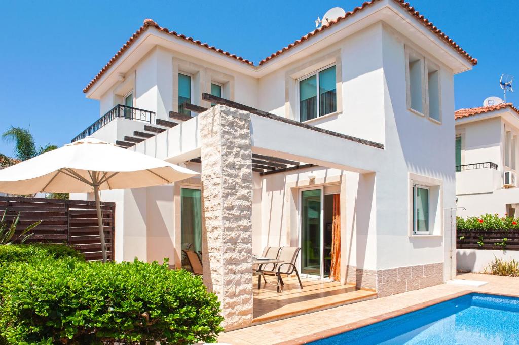 een villa met een zwembad en een huis bij Villa Danata in Protaras