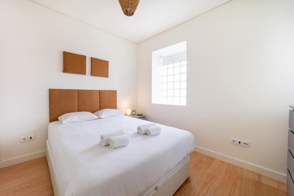 1 dormitorio con 1 cama blanca grande y toallas. en Monsanto Hill House - NO 571 1E, en Lisboa